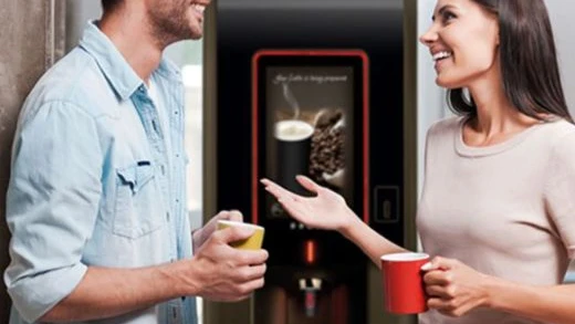 freestanding office coffee machine with people enjoying a hot beverage