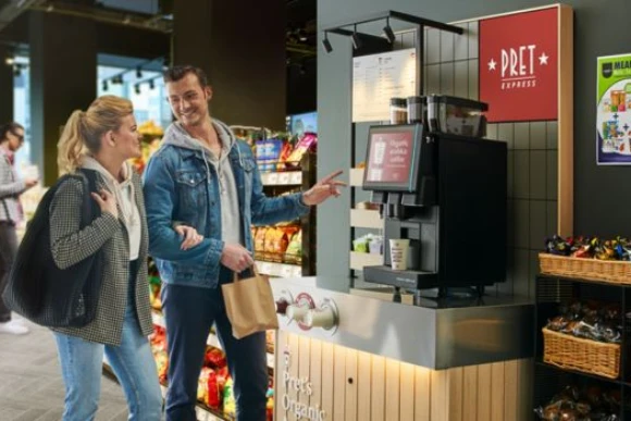 two people in casual clothes selecting a drink from a pret express unit in a forecourt store two people in casual clothes selecting a drink from a pret express unit in a forecourt store